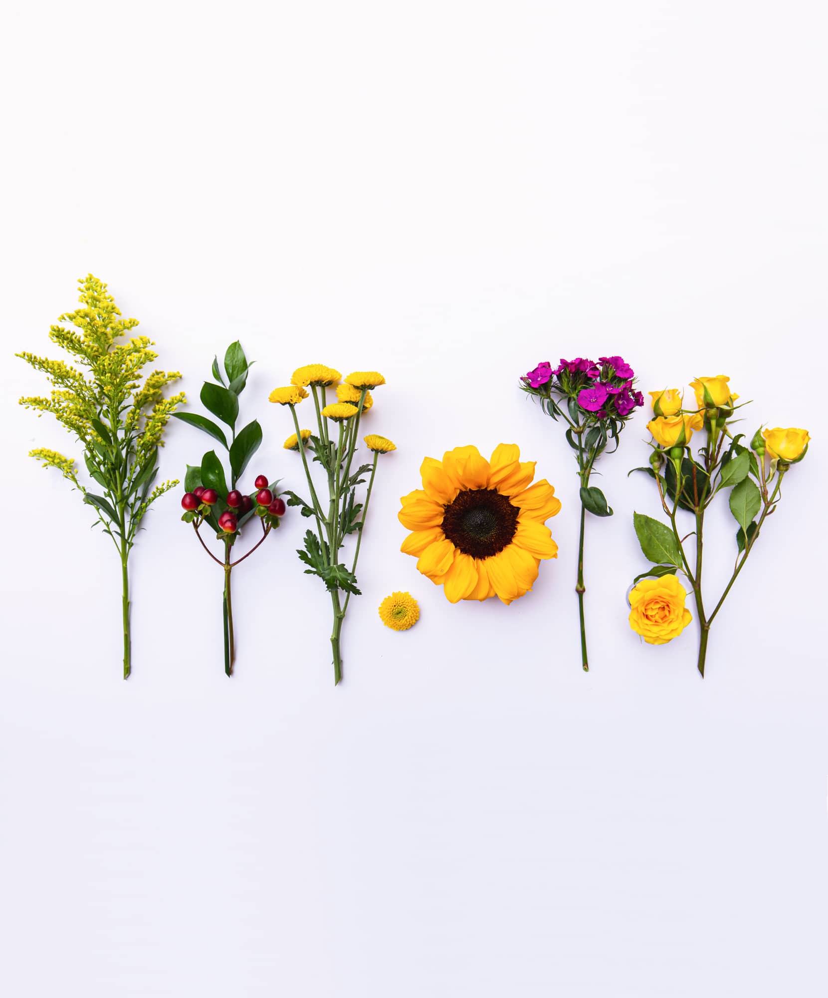 Vibrant arrangement of sunflowers, roses, and assorted greenery on a white background.