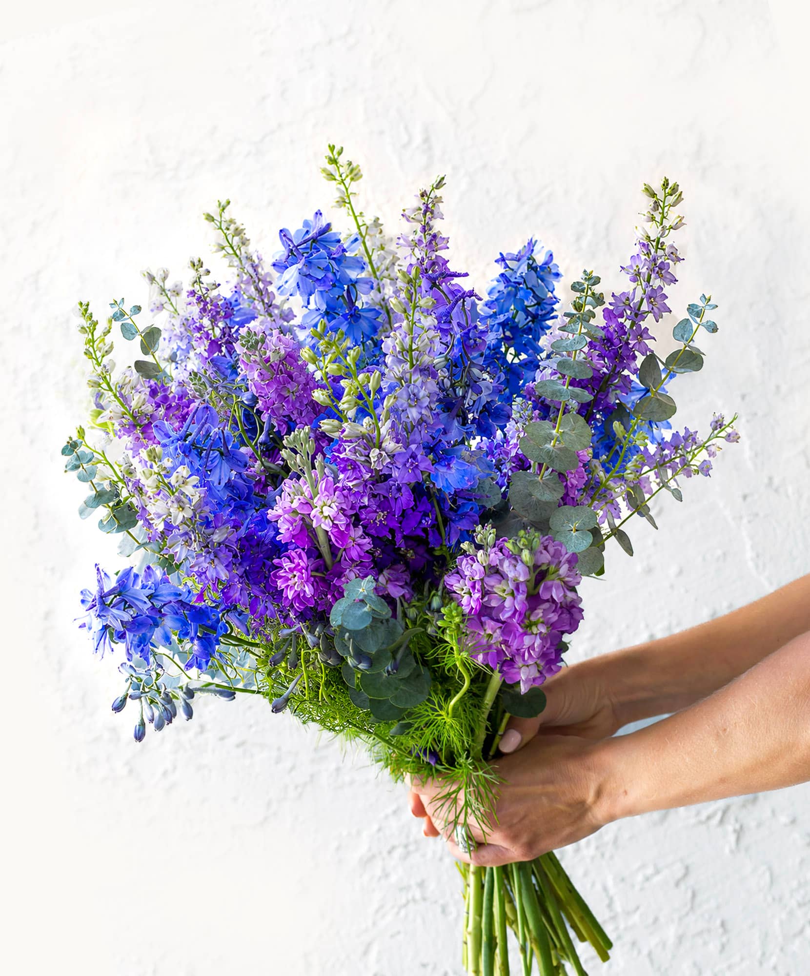 Vibrant bouquet of purple and blue flowers with eucalyptus accents, perfect for any occasion.