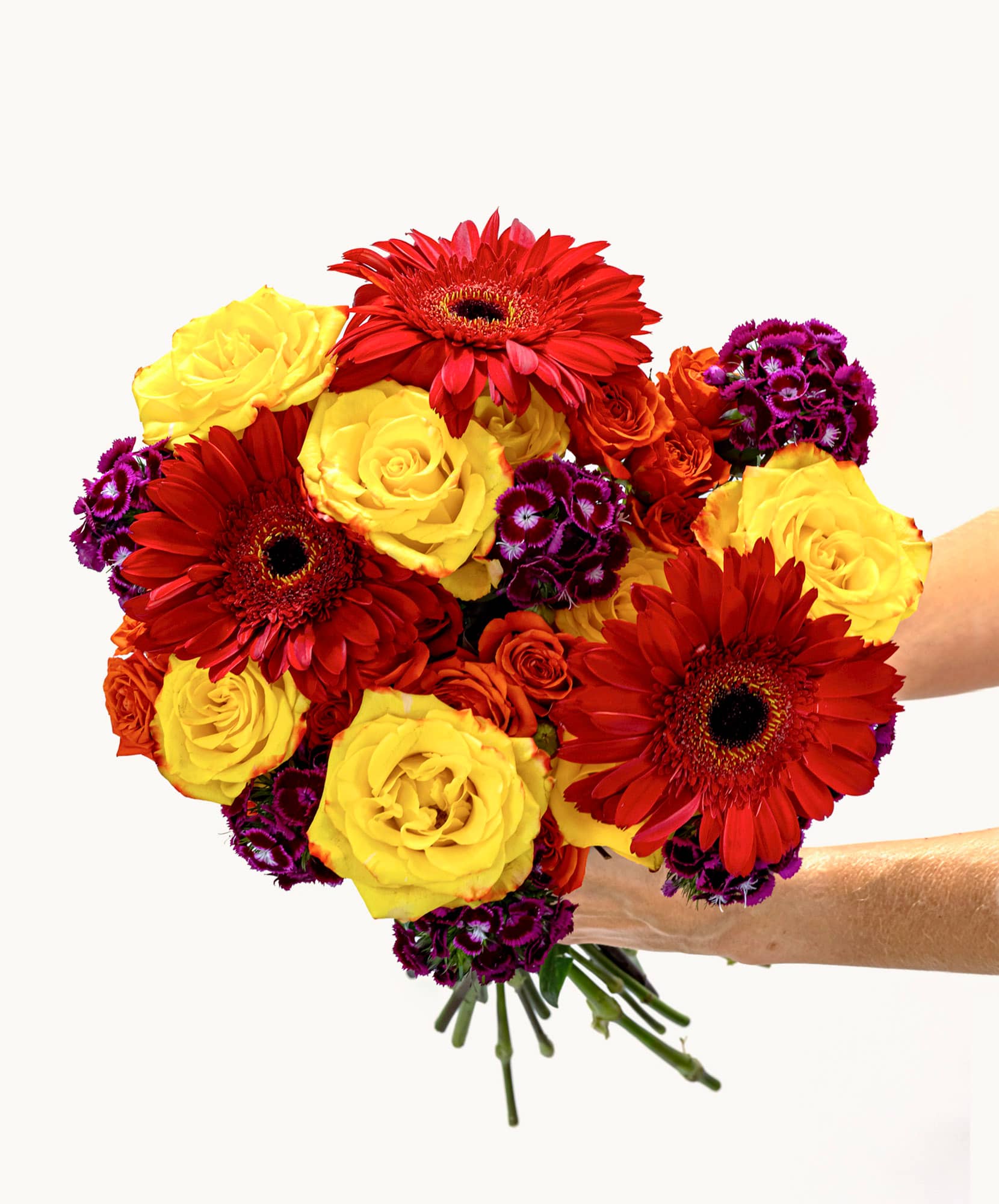 Vibrant bouquet featuring yellow roses, gerbera daisies, and purple flowers, perfect for celebrations.