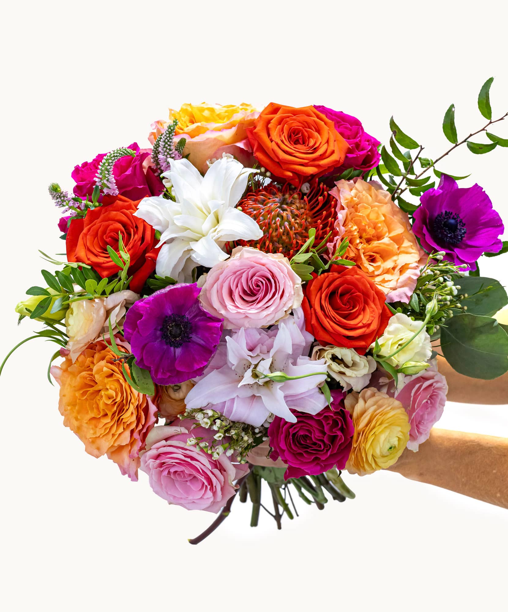 Vibrant bouquet featuring mixed roses, lilies, and anemones in a cheerful floral design.