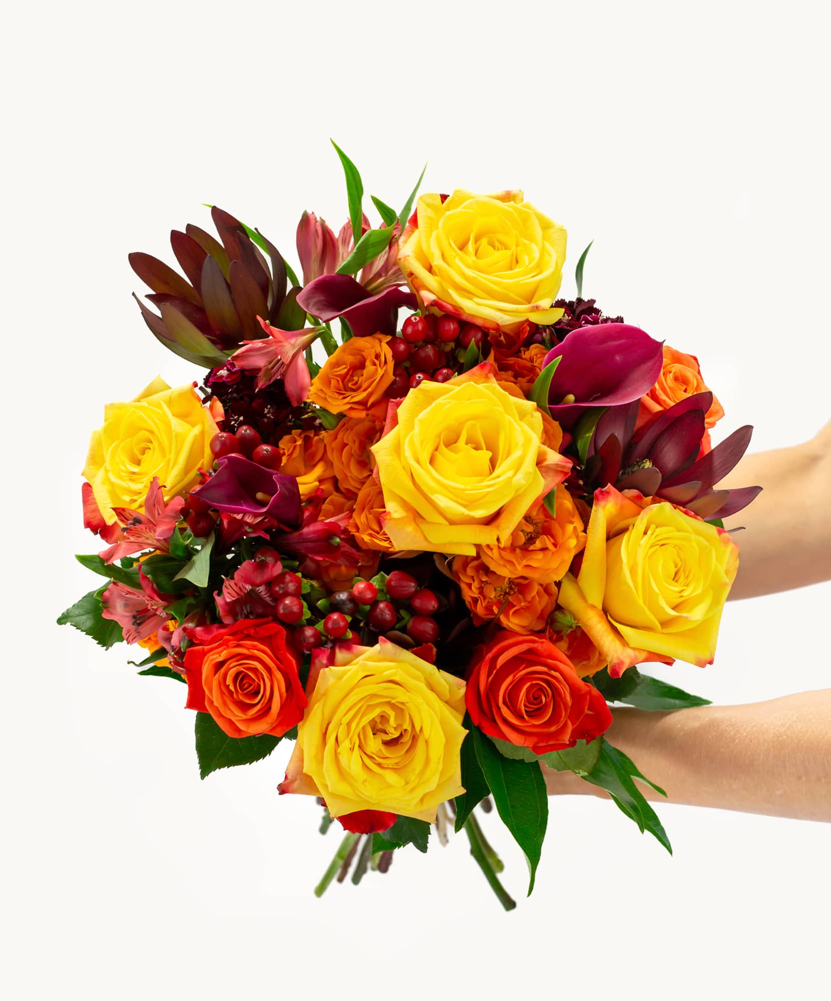 Vibrant bouquet of yellow and orange roses mixed with lush greenery, perfect for celebrations.